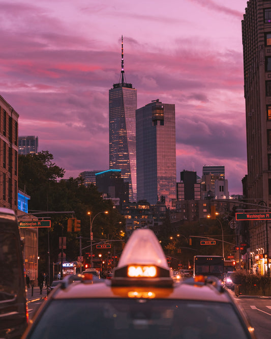 Close up of the numbers on top of a yellow cab in New York CIty during a bright pink sunset