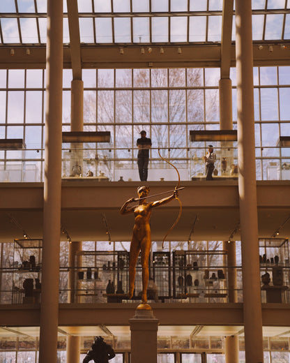 Looking up at a statue in the glass room at The Met