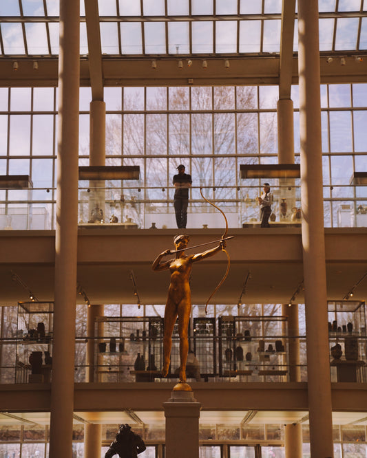 Looking up at a statue in the glass room at The Met